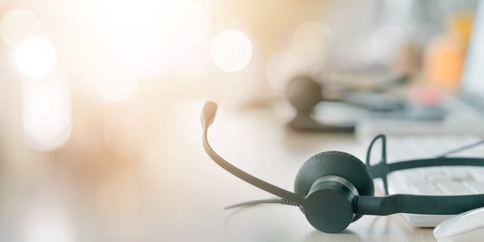 call-center-empty-workstation-with-headphones